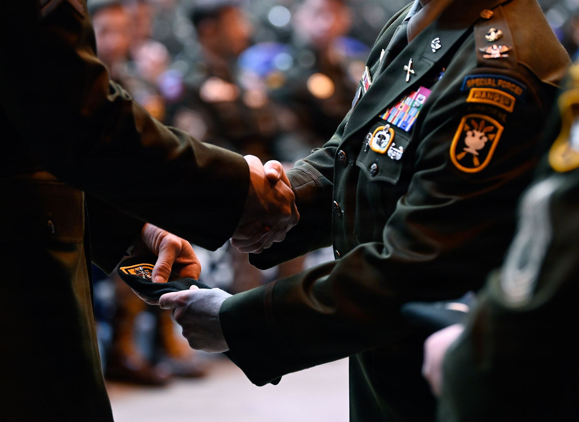 Military personnel shaking hands at ceremony.