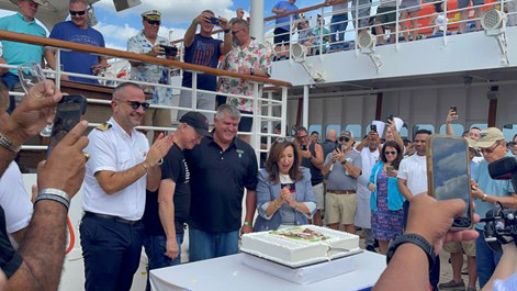 People celebrating with a cake on a cruise ship.