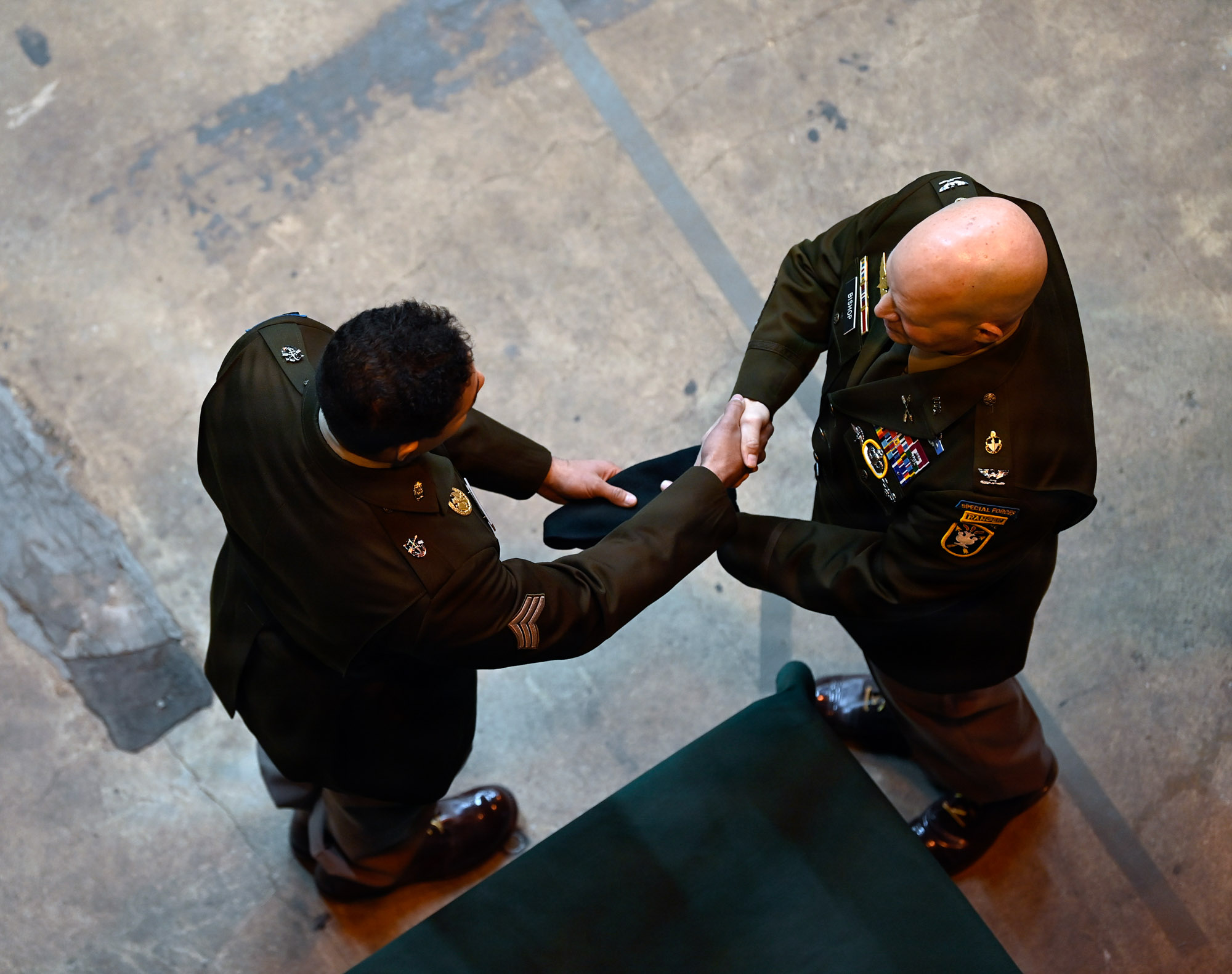 Military officers shaking hands at ceremony.