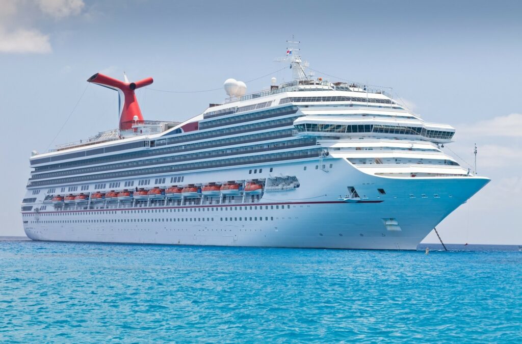 Large white cruise ship sailing on turquoise ocean