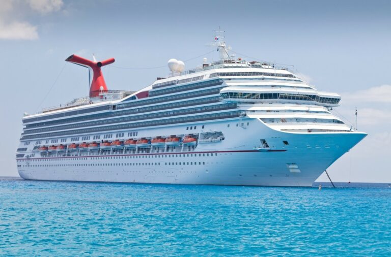 Large white cruise ship sailing on turquoise ocean