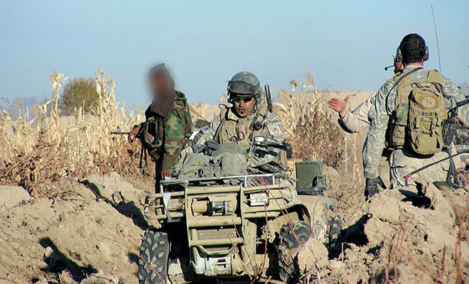 Soldiers using unmanned robot vehicle in field operation.