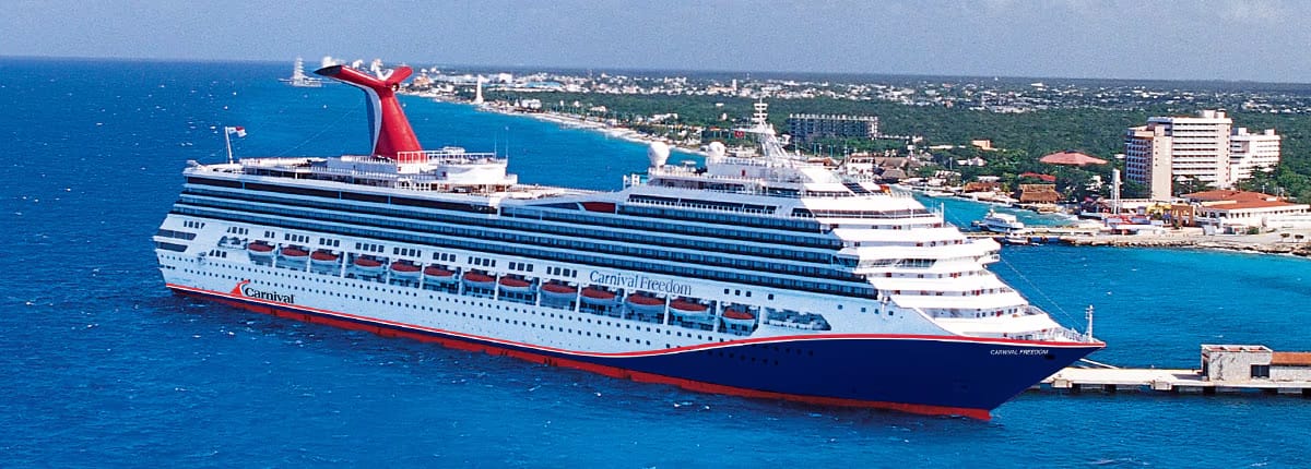 Cruise ship docked at Caribbean port, blue ocean view.