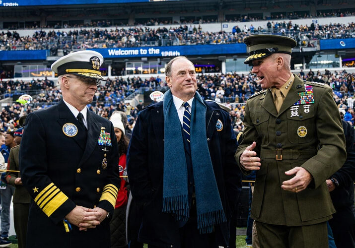 Military officers and official at a football game.