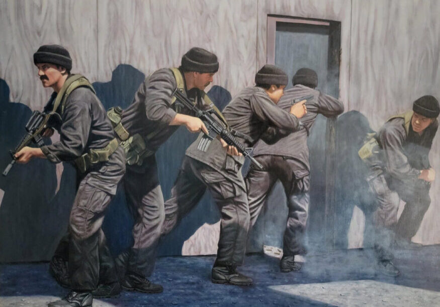 Military team in tactical formation entering building.
