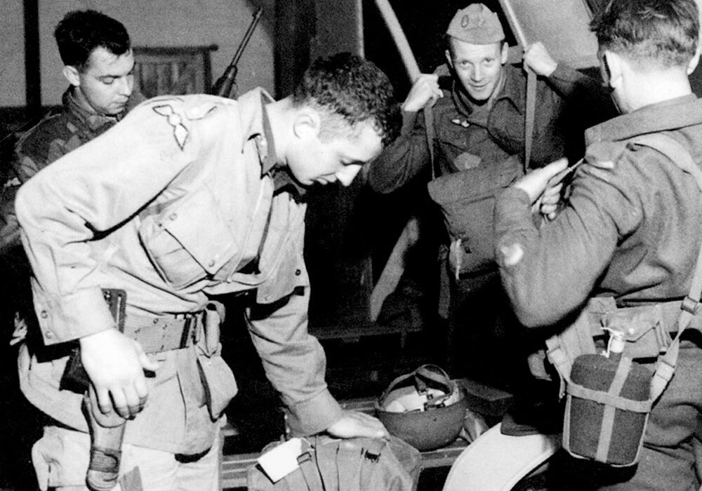 World War II soldiers preparing gear indoors