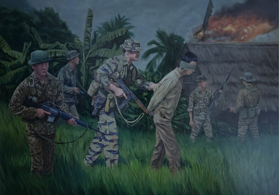 Soldiers escorting a blindfolded prisoner in jungle.