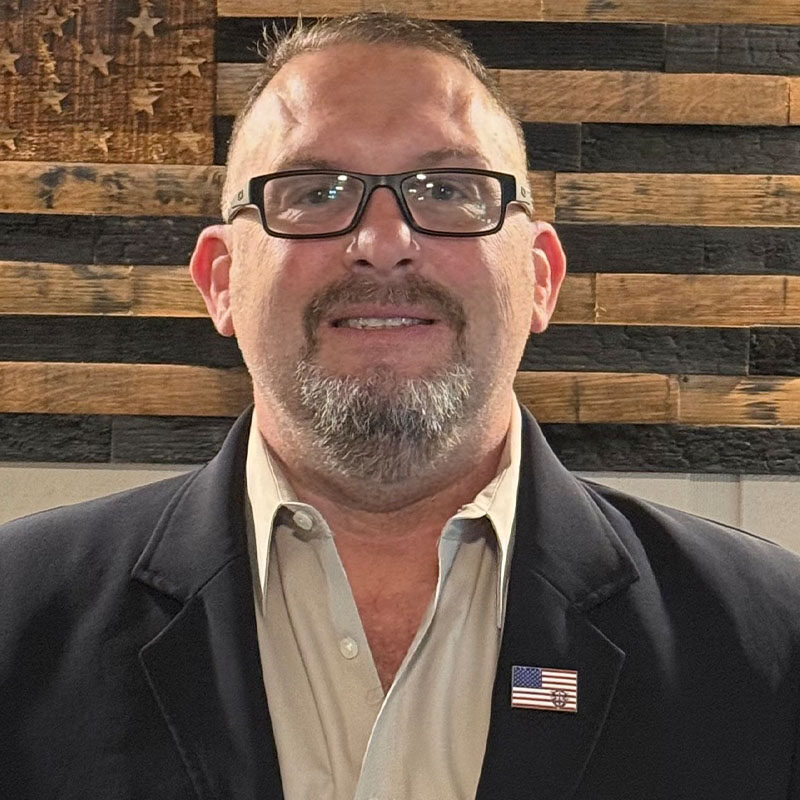 Man wearing glasses with American flag pin