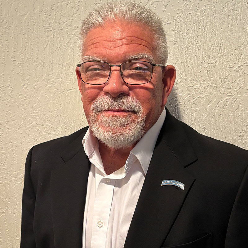 Older man in suit with glasses smiling
