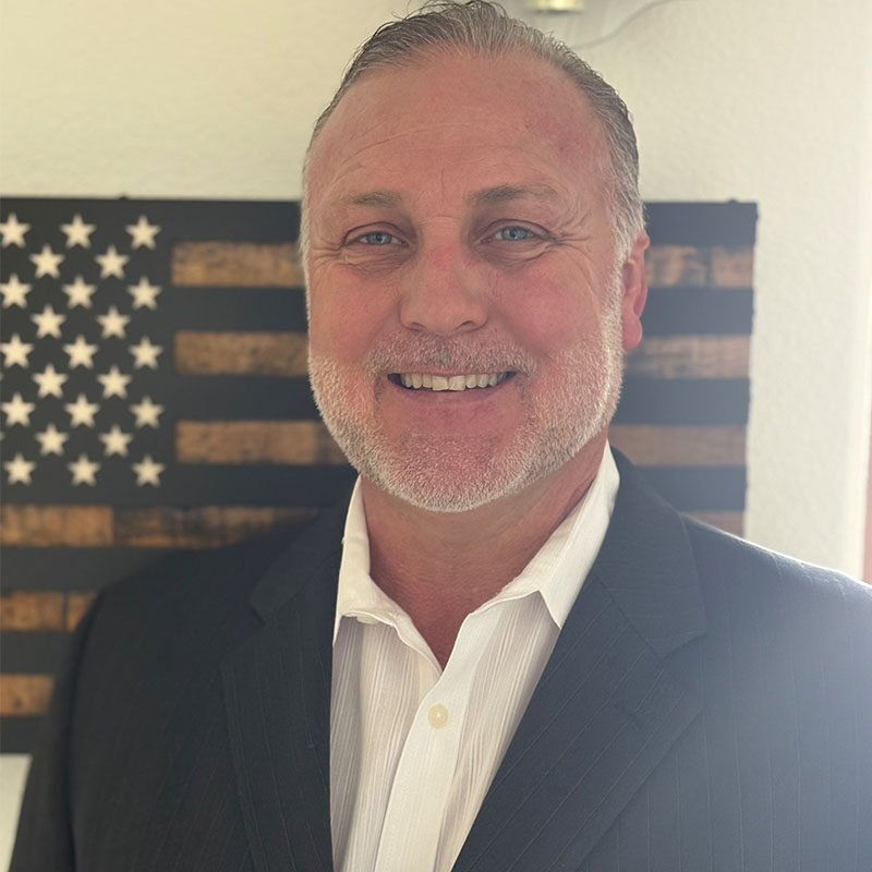 Smiling man in suit before American flag