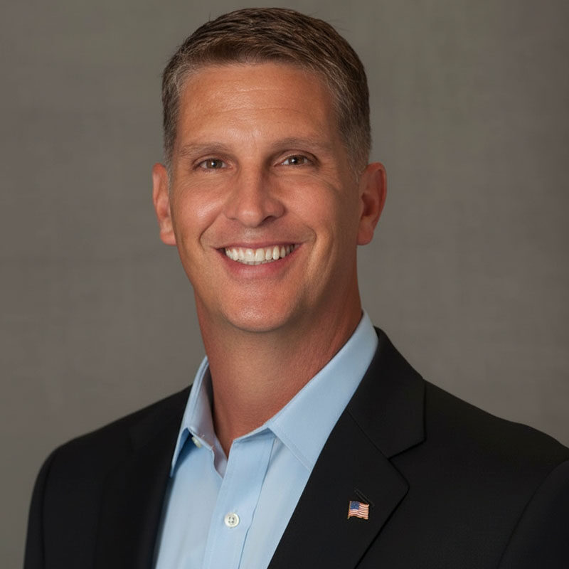 Smiling man in suit with American flag pin